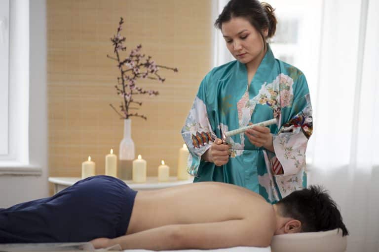 Therapist performing authentic Thai massage stretches on client at Wellness Haven JVC